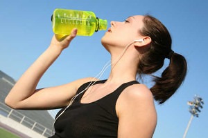 A woman athlete drinking after a long run
